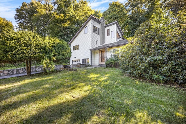 rear view of house featuring a yard and a chimney