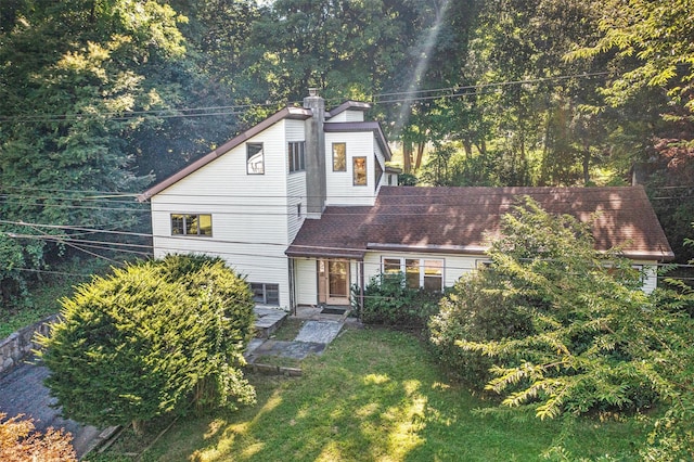 view of front of house with a front yard and a chimney