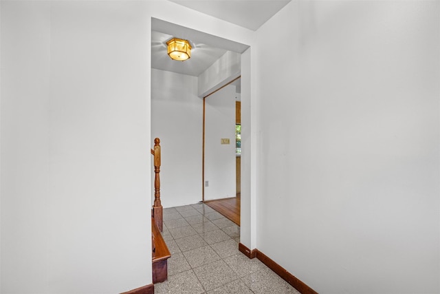hallway featuring baseboards and granite finish floor