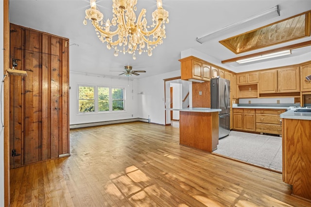kitchen featuring open floor plan, light countertops, light wood-type flooring, freestanding refrigerator, and a baseboard heating unit