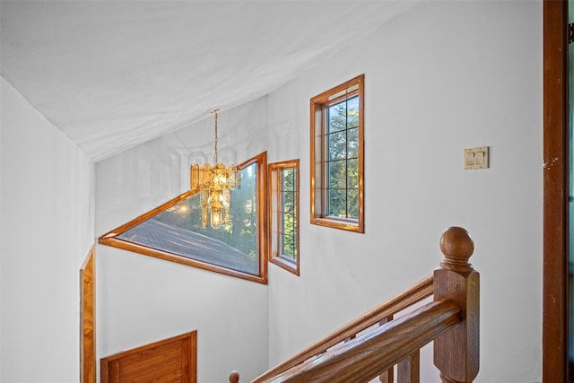 stairway featuring a notable chandelier