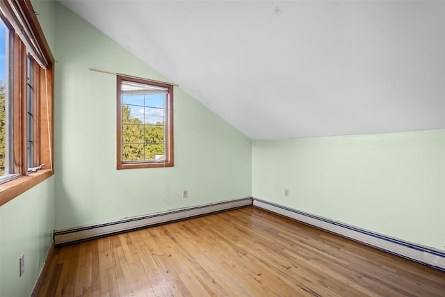 bonus room with a baseboard heating unit, a wealth of natural light, vaulted ceiling, and hardwood / wood-style flooring