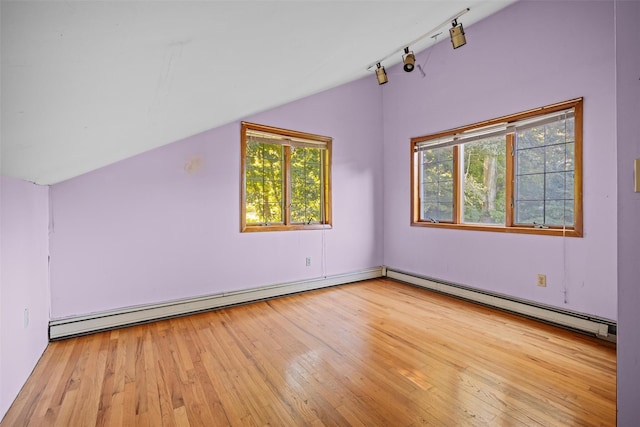 additional living space featuring a wealth of natural light, hardwood / wood-style floors, a baseboard heating unit, and lofted ceiling