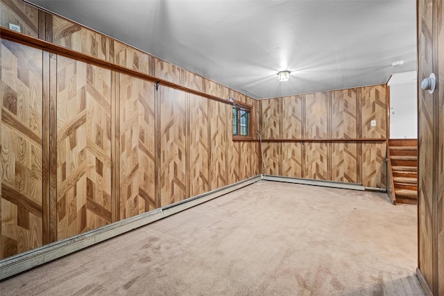 finished below grade area with carpet, baseboard heating, and wooden walls
