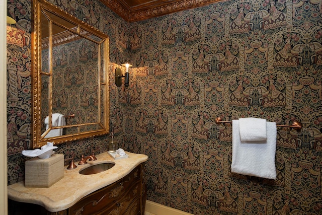 bathroom with vanity, ornamental molding, and wallpapered walls