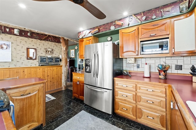 kitchen featuring tasteful backsplash, a ceiling fan, wainscoting, stainless steel appliances, and marble finish floor