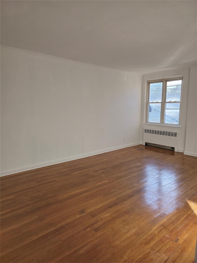2866 Philip Ave, Bronx, NY 10465 - empty room with radiator, dark wood-style flooring, and baseboards