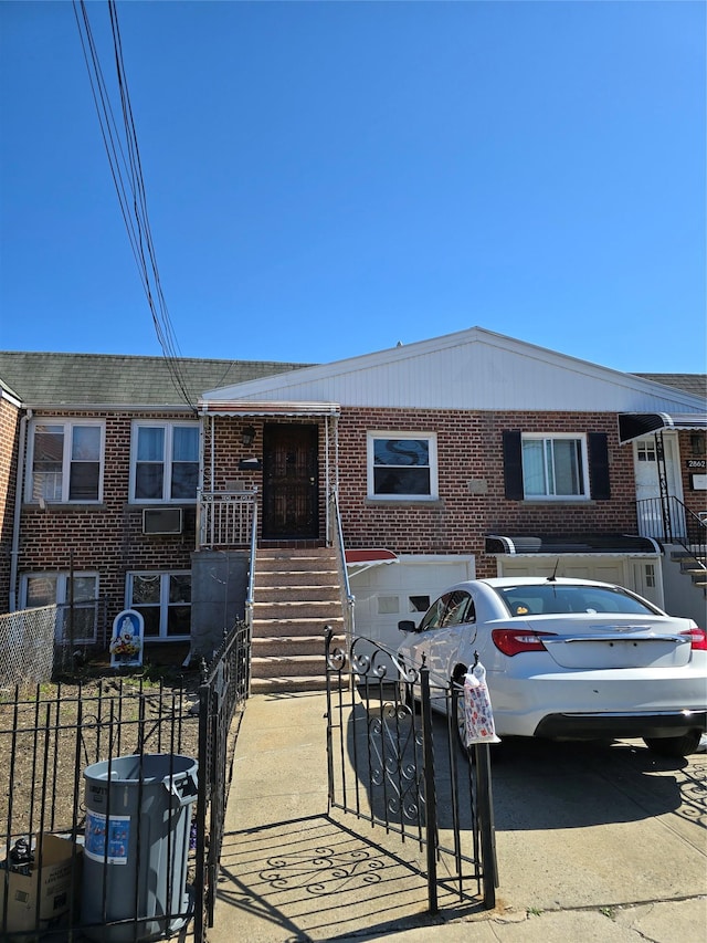 2864 Philip Ave, Bronx, NY 10465 - view of front facade with brick siding, a fenced front yard, an attached garage, and concrete driveway