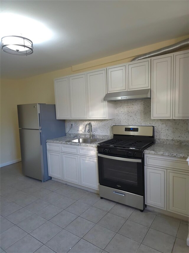 2864 Philip Ave, Bronx, NY 10465 - kitchen featuring appliances with stainless steel finishes, under cabinet range hood, a sink, light tile patterned floors, and decorative backsplash