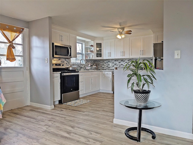 65 Biscayne Dr, Selden, NY 11784 - kitchen with appliances with stainless steel finishes, white cabinetry, a ceiling fan, and decorative backsplash