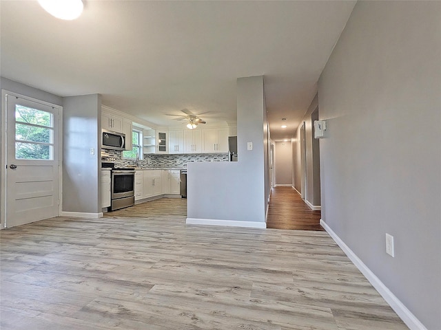 65 Biscayne Dr, Selden, NY 11784 - kitchen featuring stainless steel appliances, white cabinetry, baseboards, and light wood-style floors