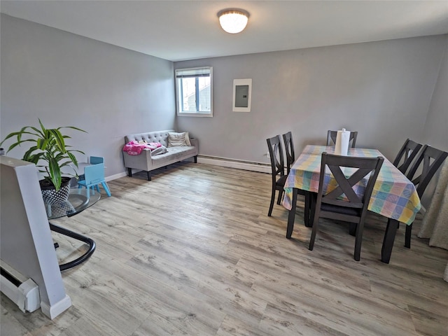 65 Biscayne Dr, Selden, NY 11784 - dining area featuring a baseboard heating unit, electric panel, wood finished floors, and baseboards