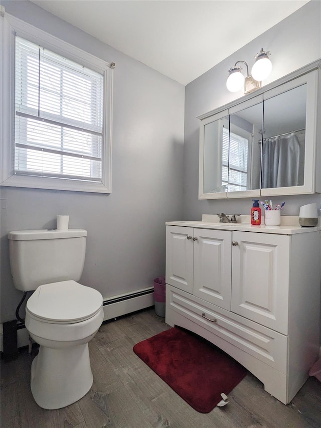 65 Biscayne Dr, Selden, NY 11784 - full bathroom featuring a baseboard heating unit, wood finished floors, vanity, and toilet