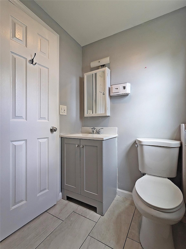 65 Biscayne Dr, Selden, NY 11784 - half bathroom featuring baseboards, toilet, vanity, and tile patterned flooring