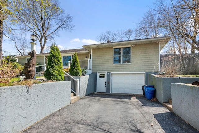 view of front of home with an attached garage, driveway, and fence