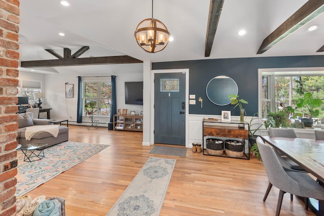 entryway featuring beamed ceiling, baseboard heating, a chandelier, and light wood-type flooring