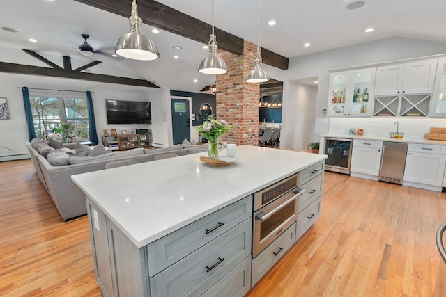 kitchen featuring white cabinets, tasteful backsplash, lofted ceiling with beams, and wine cooler