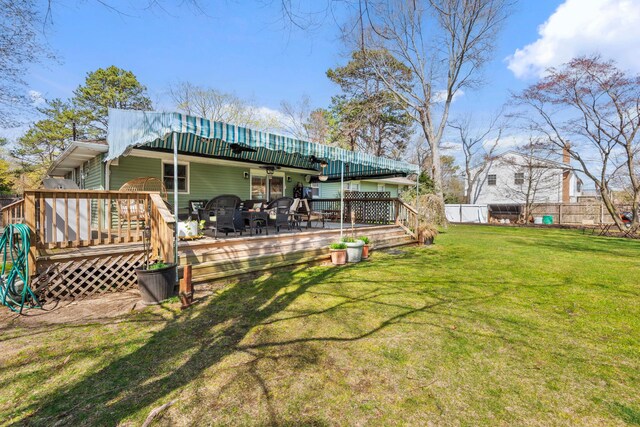 back of house with a lawn, a wooden deck, fence, and a ceiling fan