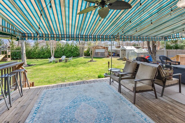 view of patio with a storage shed, fence, a wooden deck, ceiling fan, and an outdoor structure