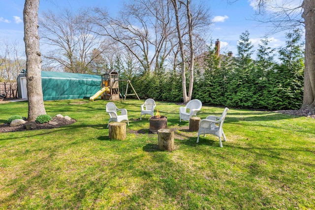 view of yard with a fire pit and a playground