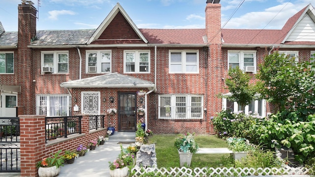 150-31 Hoover Ave, Briarwood, NY 11432 - view of property featuring brick siding, a chimney, and cooling unit