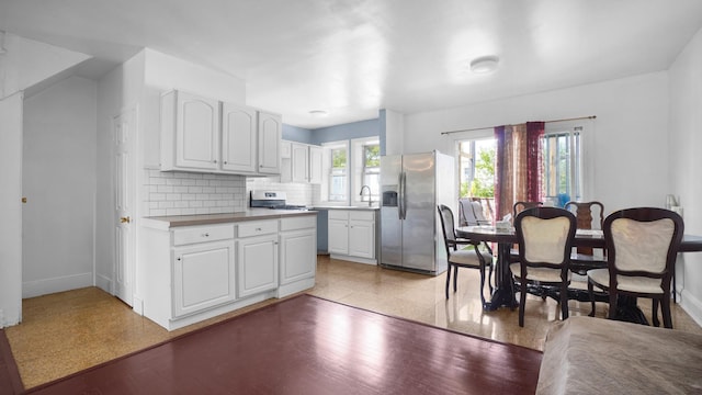 150-31 Hoover Ave, Briarwood, NY 11432 - kitchen featuring stainless steel appliances, white cabinetry, and decorative backsplash