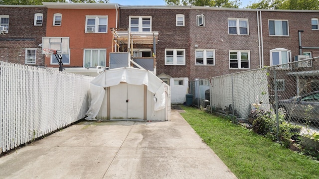 150-31 Hoover Ave, Briarwood, NY 11432 - back of house featuring a fenced backyard, a storage unit, and brick siding