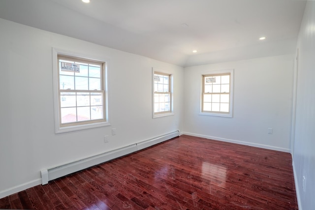 empty room with baseboard heating, wood finished floors, and recessed lighting