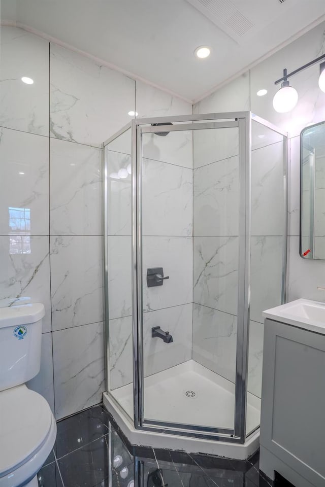 bathroom featuring toilet, a stall shower, vanity, and recessed lighting