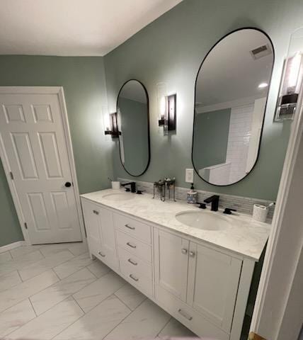 full bath with visible vents, marble finish floor, a sink, and double vanity
