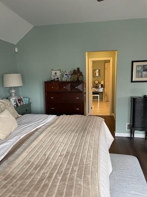 bedroom featuring baseboards, dark wood-style floors, and lofted ceiling