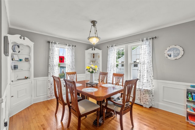 14 Kelly Ct, Kings Park, NY 11754 - dining room featuring healthy amount of natural light, light wood-type flooring, wainscoting, ornamental molding, and a decorative wall