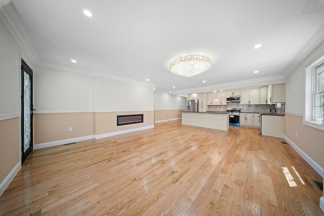 kitchen featuring recessed lighting, open floor plan, appliances with stainless steel finishes, and dark countertops