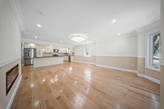 unfurnished living room featuring baseboards, ornamental molding, recessed lighting, and light wood-style flooring