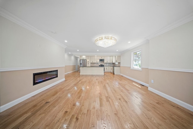 unfurnished living room featuring recessed lighting, crown molding, baseboards, and a glass covered fireplace