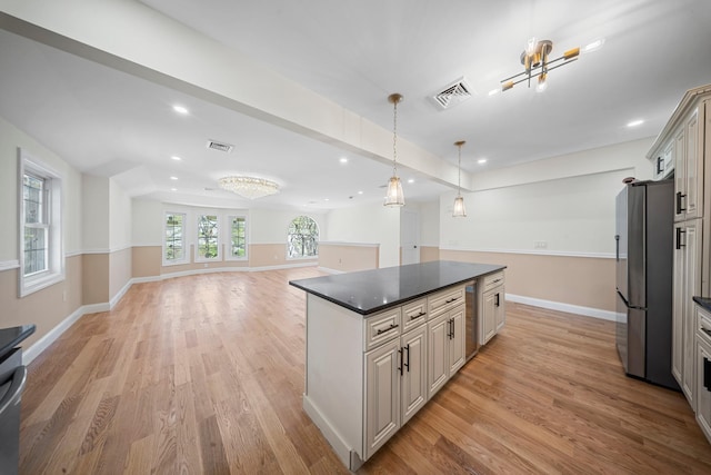 kitchen featuring freestanding refrigerator, light wood finished floors, open floor plan, and visible vents