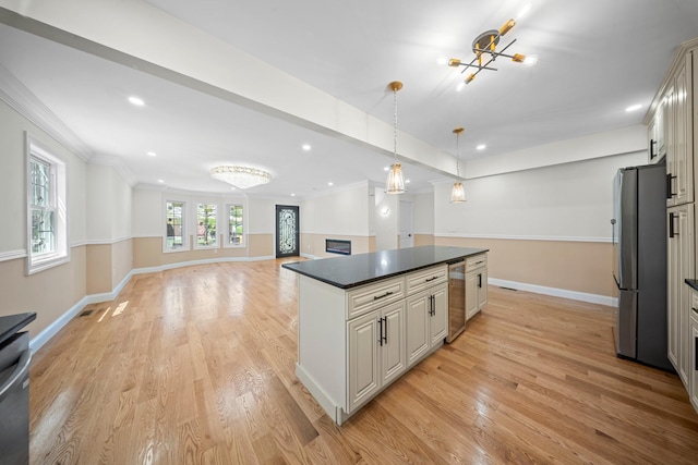 kitchen featuring baseboards, light wood finished floors, dark countertops, and stainless steel appliances