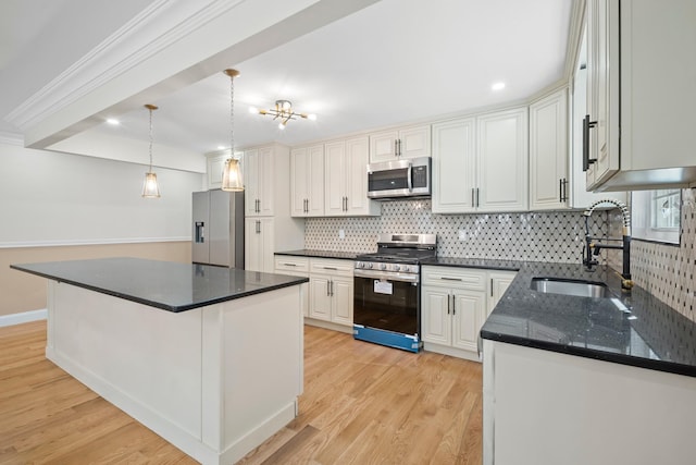 kitchen with a sink, decorative backsplash, light wood-style floors, and stainless steel appliances