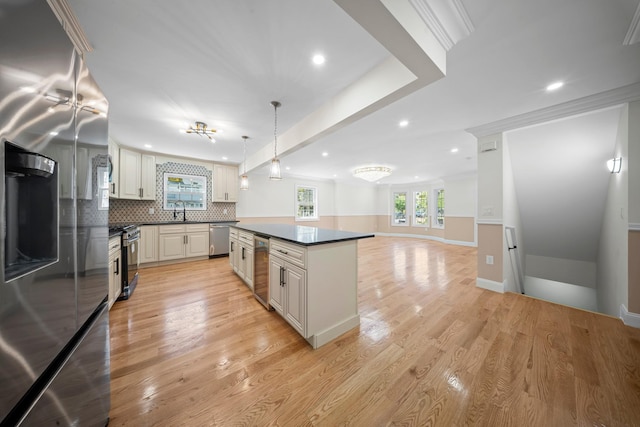 kitchen featuring dark countertops, a sink, a center island, stainless steel appliances, and recessed lighting