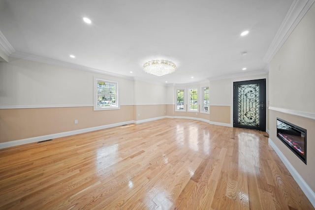 unfurnished living room with recessed lighting, light wood-style flooring, crown molding, and baseboards