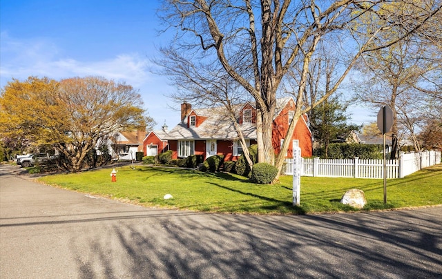 view of front of home with fence, a chimney, and a front yard