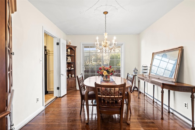 dining space featuring baseboards, a notable chandelier, and dark wood-type flooring