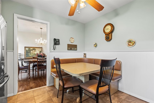 dining area featuring ceiling fan with notable chandelier and tile patterned flooring