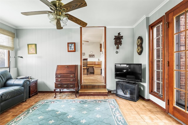 living room with parquet flooring, crown molding, baseboards, and a ceiling fan