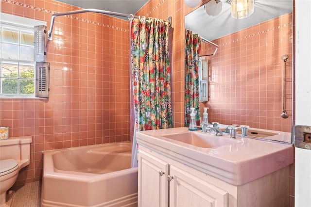 full bath featuring shower / bath combo, toilet, vanity, and tile walls