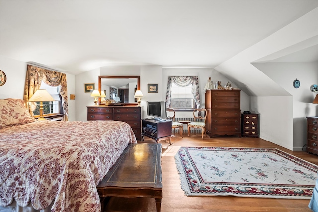 bedroom featuring lofted ceiling and wood finished floors