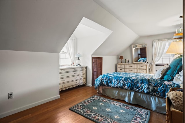 bedroom with lofted ceiling, wood finished floors, multiple windows, and baseboards
