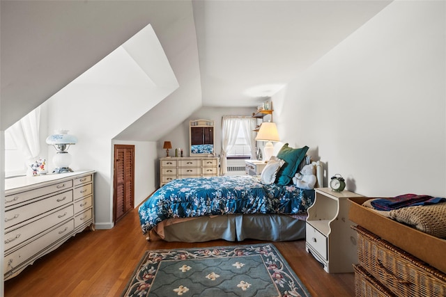 bedroom with lofted ceiling, wood finished floors, and baseboards