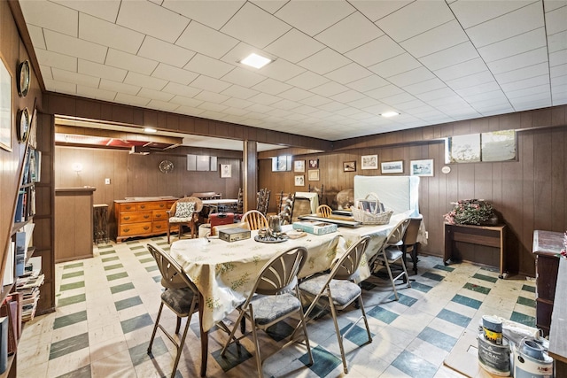 dining room featuring wood walls and tile patterned floors