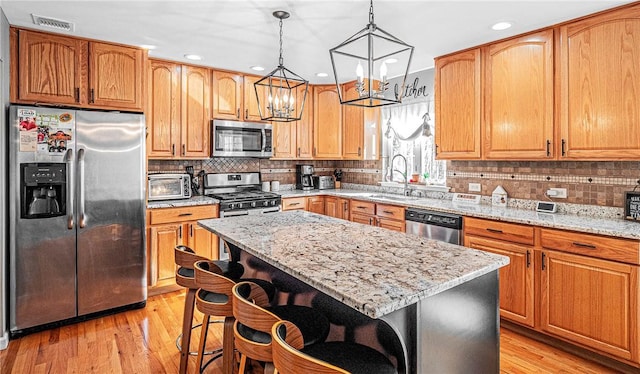kitchen with light stone countertops, visible vents, a chandelier, and appliances with stainless steel finishes